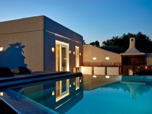 卡马利Incognito Beach Villa Santorini的一座晚上设有游泳池的房子