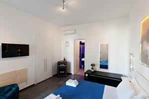 托雷拉皮罗Bed & Blues的白色的客房配有蓝色的床和电视。