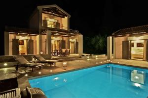 米尼亚艾拉雅别墅酒店的夜间在房子前面的游泳池