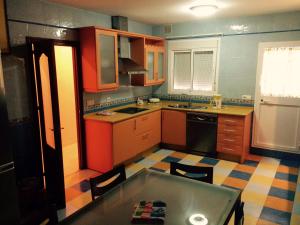 桑卢卡尔-德巴拉梅达多纳拿公寓式酒店的厨房配有橙色和蓝色的橱柜和桌子