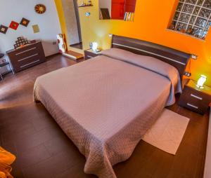 古斯皮尼B&B Annalu'的橙色墙壁的客房内的一张大床