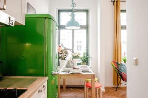 莱比锡Enjoy Leipzig的带桌子的厨房内的绿色冰箱
