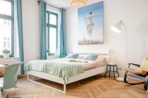 莱比锡Enjoy Leipzig的卧室配有一张床,墙上挂有绘画作品