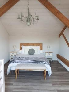 Saint-Point-LacL'Ecrin du Lac的一间卧室配有一张大床和一个吊灯。