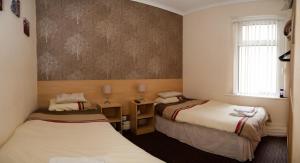 布莱克浦彭林旅馆的客房设有两张床和窗户。