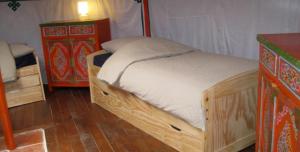 塞雷拉龙德达奎瓦夫斯蒙古包的一间卧室配有木床和梳妆台