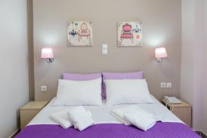 比雷埃夫斯LUX Hotel的一间卧室配有一张带两个白色枕头的紫色床