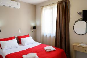 比雷埃夫斯LUX Hotel的一间卧室配有红色的床和2条毛巾