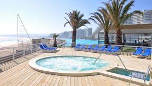 阿尔加罗沃San Alfonso del Mar Puerto del Sur的一个带蓝色躺椅的游泳池和海滩