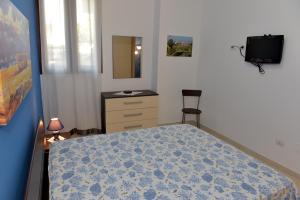 切萨雷奥港Bilocali Civico16的一间卧室配有一张床、梳妆台和椅子