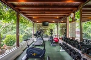 查汶Muang Samui Spa Resort - SHA Extra Plus的一个带跑步机和椭圆机的健身房,位于带窗户的房间内