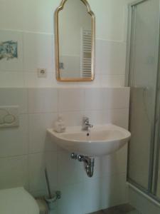 Wiltingen魏茵古特施密茨 - 西蒙酒店的一间带水槽和镜子的浴室