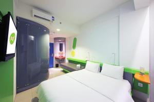 雅加达雅加达太贝特POP!酒店的卧室配有白色的床和电视。