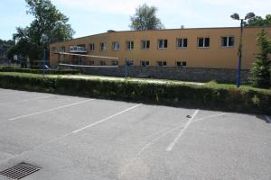 拉贝河畔罗乌德尼采Sporthotel BK Pod Lipou的大楼前的一个空停车位