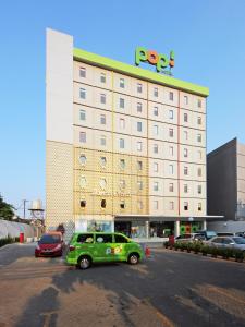 雅加达雅加达太贝特POP!酒店的停在酒店前的绿色汽车