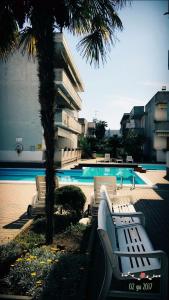 阿尔巴·阿德里亚蒂卡Claudia Residence的一组白色长凳,位于游泳池旁