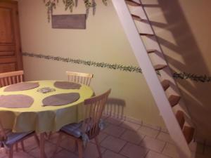 Civray-de-Tourainegite la Pinetterie的一间带桌子和螺旋楼梯的用餐室