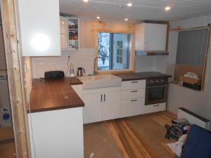 SkauloLakeside House in Lapland的厨房配有白色橱柜和水槽