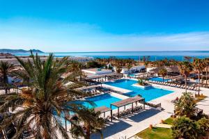 雷塔马尔巴塞罗加塔角酒店的享有度假村的空中景致,设有2个游泳池和棕榈树