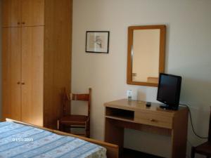 奥杰比奥IL万博乐酒店的一间卧室配有一张床和一张书桌及电视