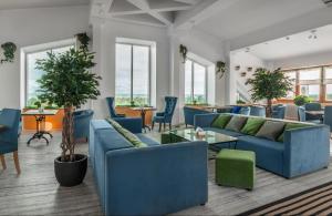 泽列诺戈尔斯克蓝宝石Spa酒店的客厅配有蓝色的沙发和椅子