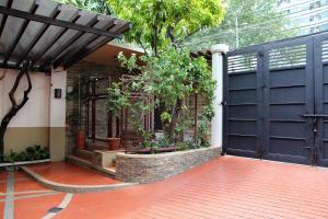 马尼拉新马尼拉住宿加早餐旅馆的一座种植了植物的房子里的一个黑色车库门