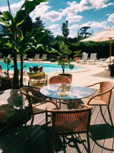 普里瓦尚米特酒店的一个带桌椅的庭院和一个游泳池