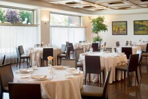 贝加莫星际克里斯塔罗宫酒店的用餐室配有桌椅和白色桌布
