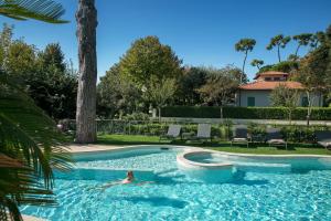 马尔米堡圣茂利裘丝酒店的在院子里的游泳池游泳的人