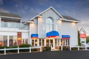 麦基诺城滨水华美达酒店的蓝色和红色的白色大建筑