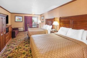 麦基诺城滨水华美达酒店的酒店客房设有两张床和电视。