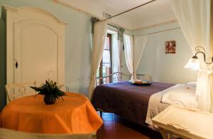 萨杜勒尼亚B&B 8380 Saturnia Terme的一间卧室配有一张床、一张桌子和一个窗户。
