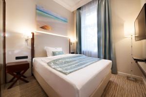 韦尔斯亚德里亚精品酒店的卧室设有一张白色大床和一扇窗户。