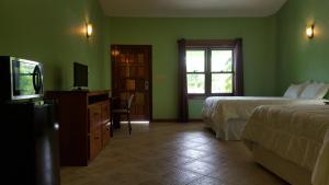 蓬塔戈尔达Mahogany Villas的酒店客房设有两张床和电视。