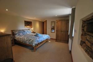 卡林顿Lakeview Cottage的一间卧室设有一张床和石墙