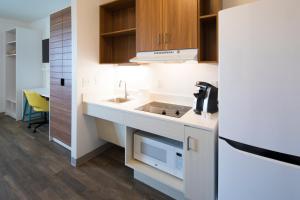 康科德Uptown Suites Extended Stay Charlotte NC - Concord的厨房配有水槽和微波炉
