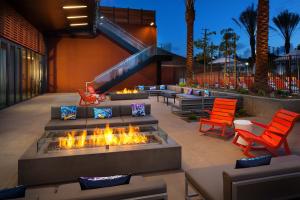 埃尔塞贡多雅乐轩埃尔塞贡多酒店 - 洛杉矶机场的庭院设有火坑和两把橙色椅子