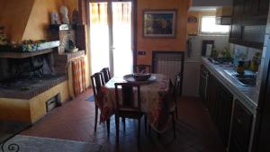菲乌米奇诺河流公寓的一间带桌椅的厨房和一间带壁炉的厨房