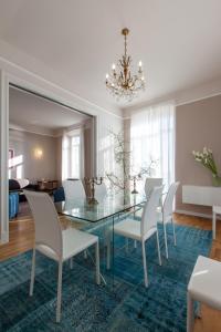 圣雷莫Casa del Mare的一间设有玻璃桌和白色椅子的用餐室