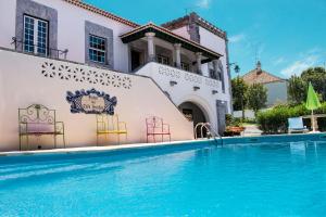 费雷拉杜阿连特茹Casa do Infante的一座别墅,在一座建筑前设有一个游泳池