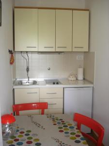 乌马格Apartman Darja的厨房配有桌子、水槽和橱柜。
