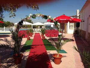 Abarán梅森德尔摩洛酒店的一条铺有红色地毯并配有椅子和雨伞的小径