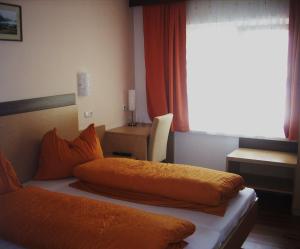 埃本塞罗特奈旅馆的卧室配有2个橙色枕头