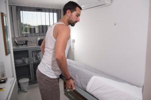 雅典Monastiraki City Sleepbox- Unspoiled Athens Apartments的站在房间床边的人