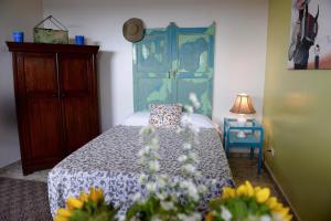 卡利魔法花园之家旅馆的一间卧室配有一张带蓝色床头板和鲜花的床