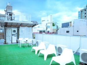 福冈福冈之花旅馆的屋顶阳台配有白色的椅子和桌子