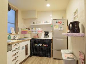 福冈福冈之花旅馆的一间带冰箱和水槽的小厨房
