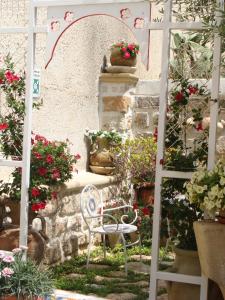 法维尼亚纳Guest House Al Gattopardo的花卉园里的白色椅子