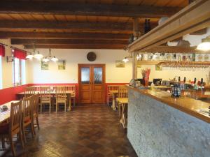 ŘetováPension Mandl的餐厅设有酒吧和桌椅