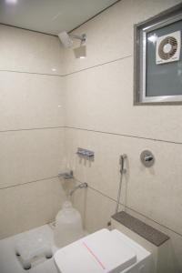苏拉特桔子国际酒店的一间带卫生间、水槽和窗户的浴室